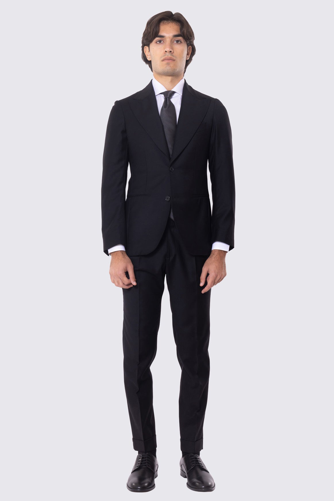 Abito nero con giacca monopetto rever a lancia tasche a filo e pantalone vita alta con fibbie laterali regolabili doppie pinces e risvolto 5cm 100% lana Flanella Carillo Drapers