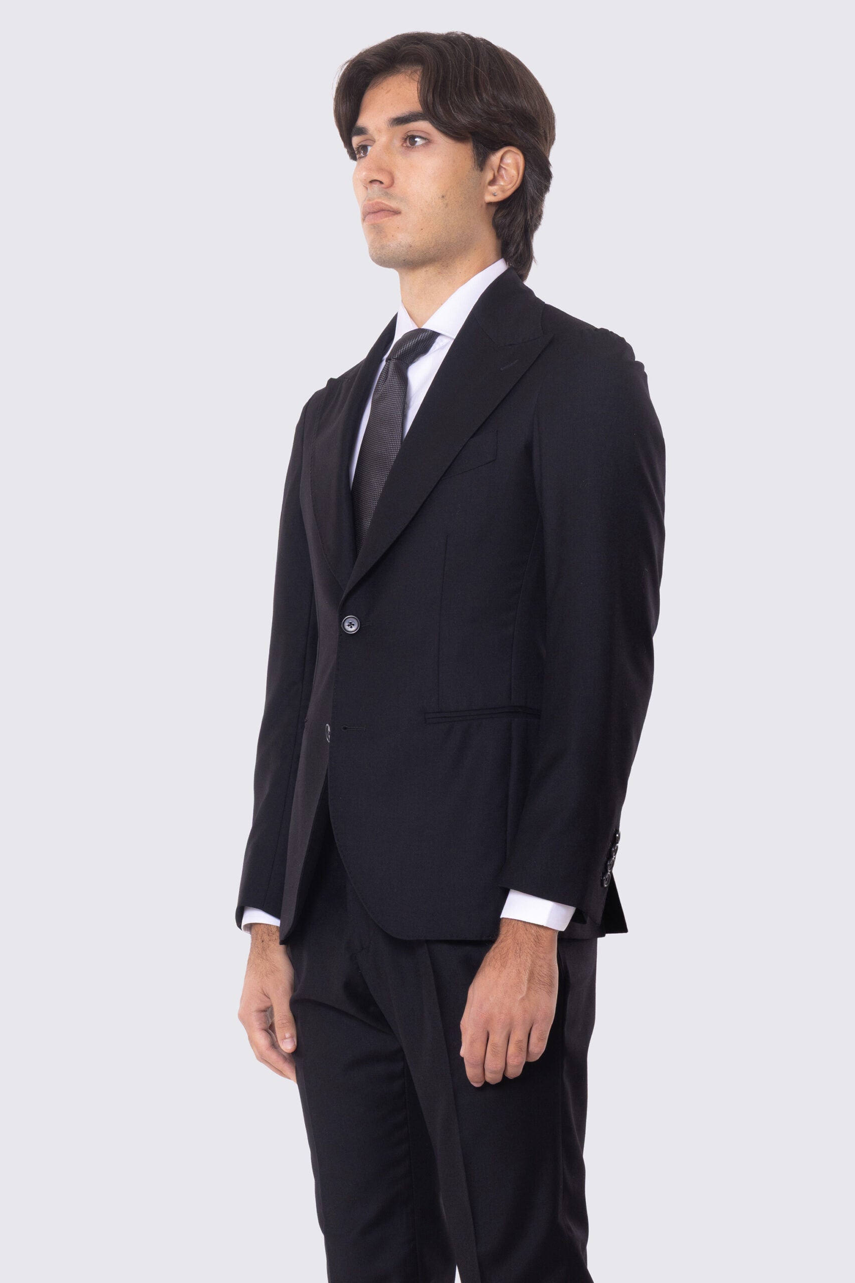 Abito nero con giacca monopetto rever a lancia tasche a filo e pantalone vita alta con fibbie laterali regolabili doppie pinces e risvolto 5cm 100% lana Flanella Carillo Drapers