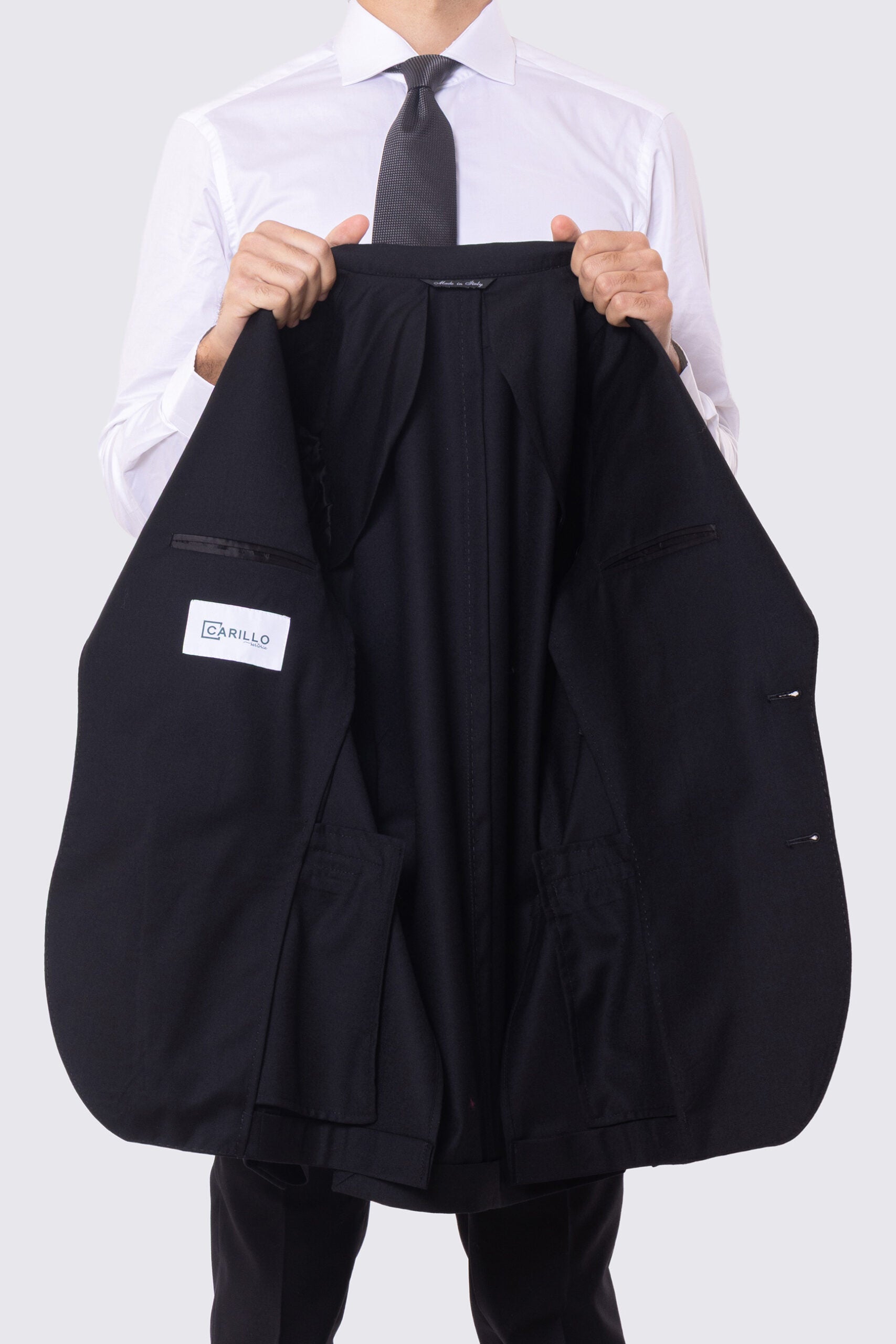 Abito nero con giacca monopetto rever a lancia tasche a filo e pantalone vita alta con fibbie laterali regolabili doppie pinces e risvolto 5cm 100% lana Flanella Carillo Drapers