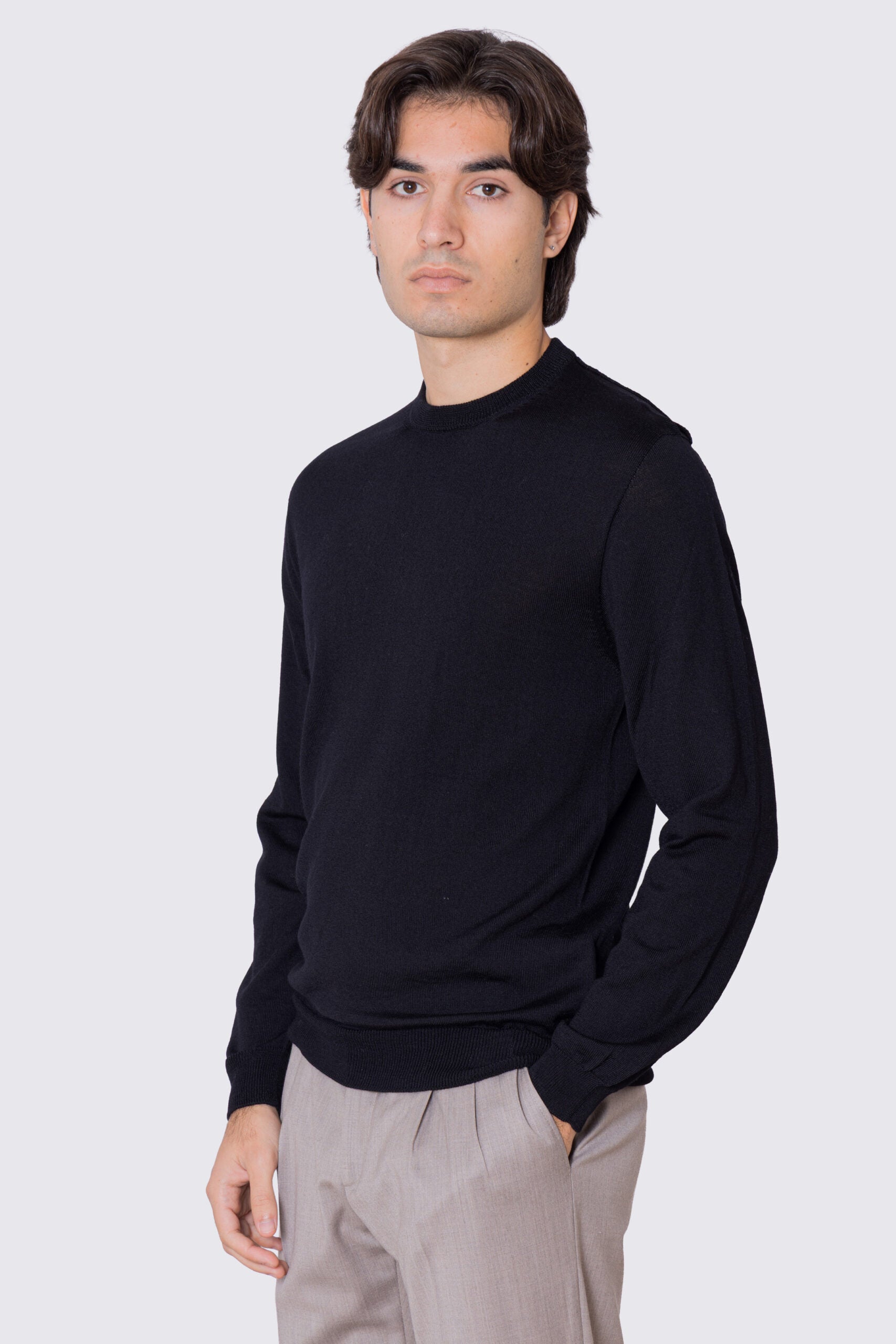 Maglione girocollo Nero in lana merinos 100% costruzione tubolare senza cuciture rifinito a mano tinta unita con elastici sulle maniche e sul fondo Finezza 12 .