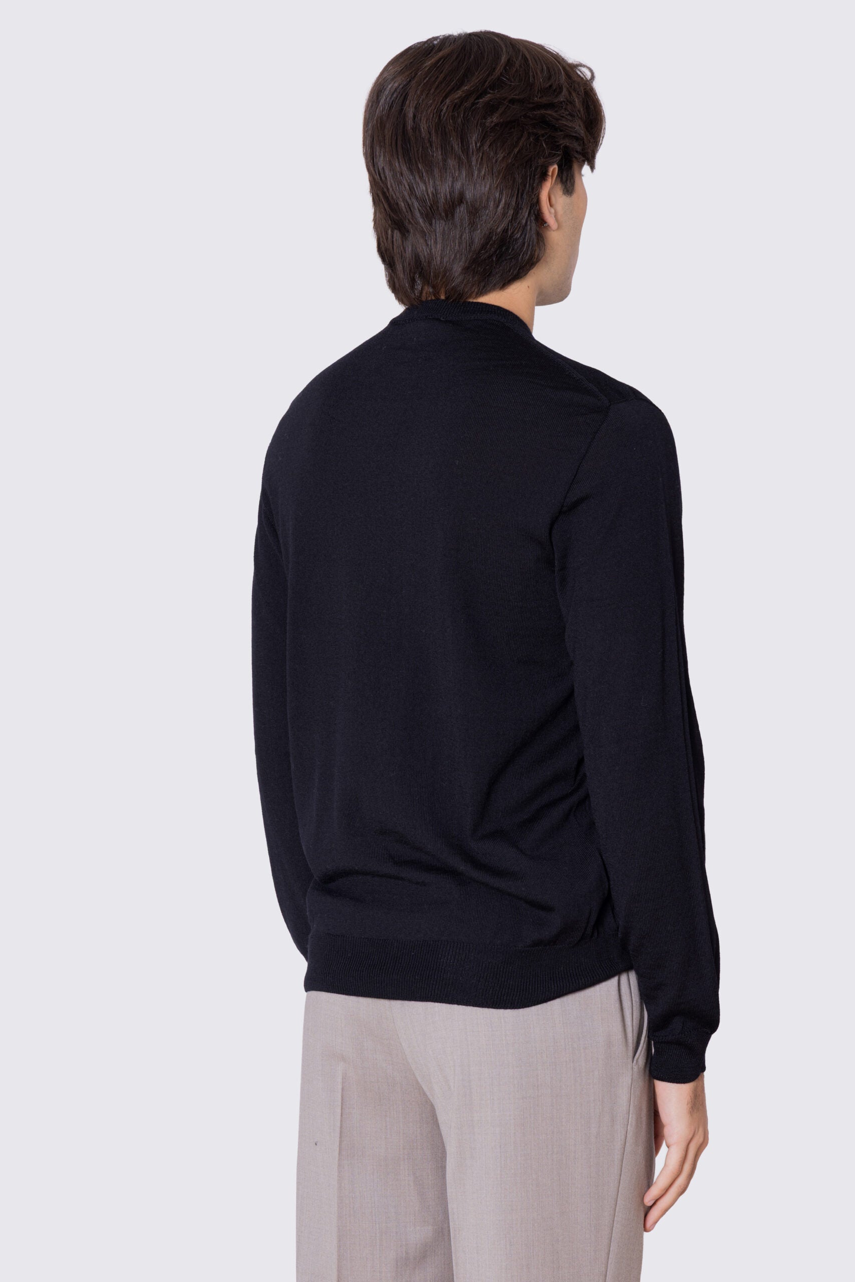 Maglione girocollo Nero in lana merinos 100% costruzione tubolare senza cuciture rifinito a mano tinta unita con elastici sulle maniche e sul fondo Finezza 12 .